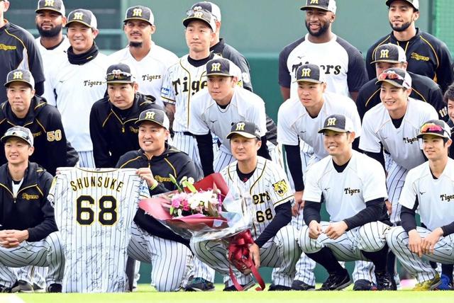 花束を手にナインに囲まれる俊介(全列中央)=21日