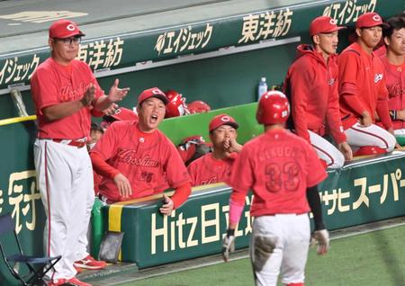 　５回、堂林の犠飛で同点に追いつき、生還した菊池（３３）を迎える新井監督（左から２人目）