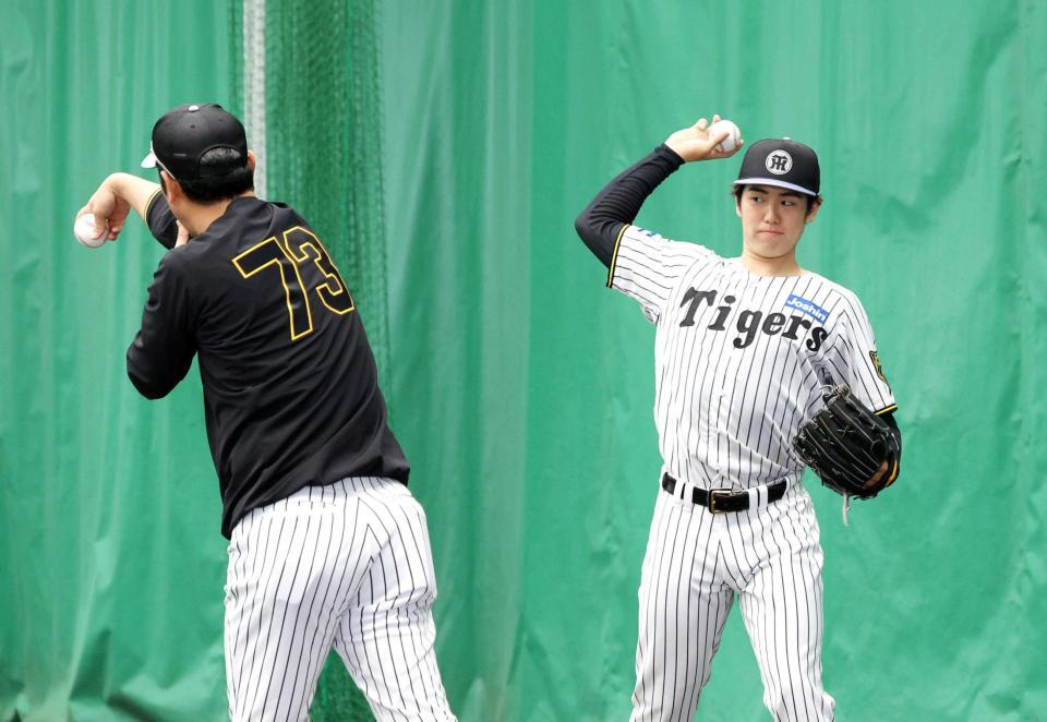 　金村投手コーチ（左）から指導を受ける石黒