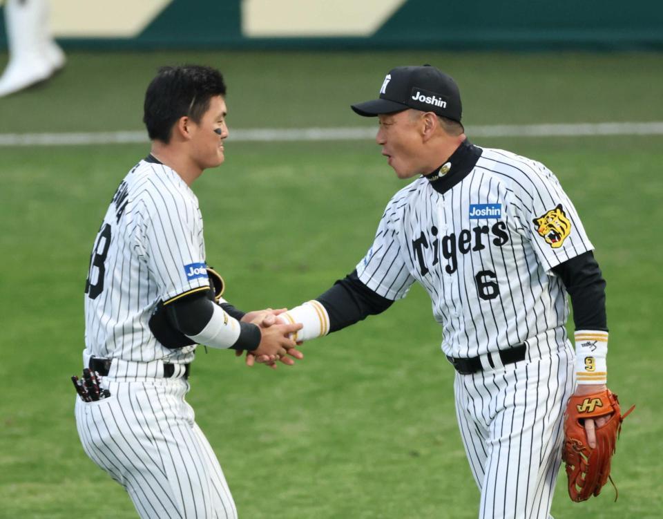 　前川（左）と握手を交わす金本氏