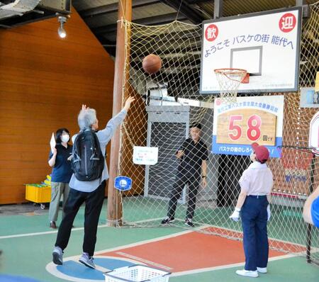 　能代駅でバスケットボールシュート体験をする乗客