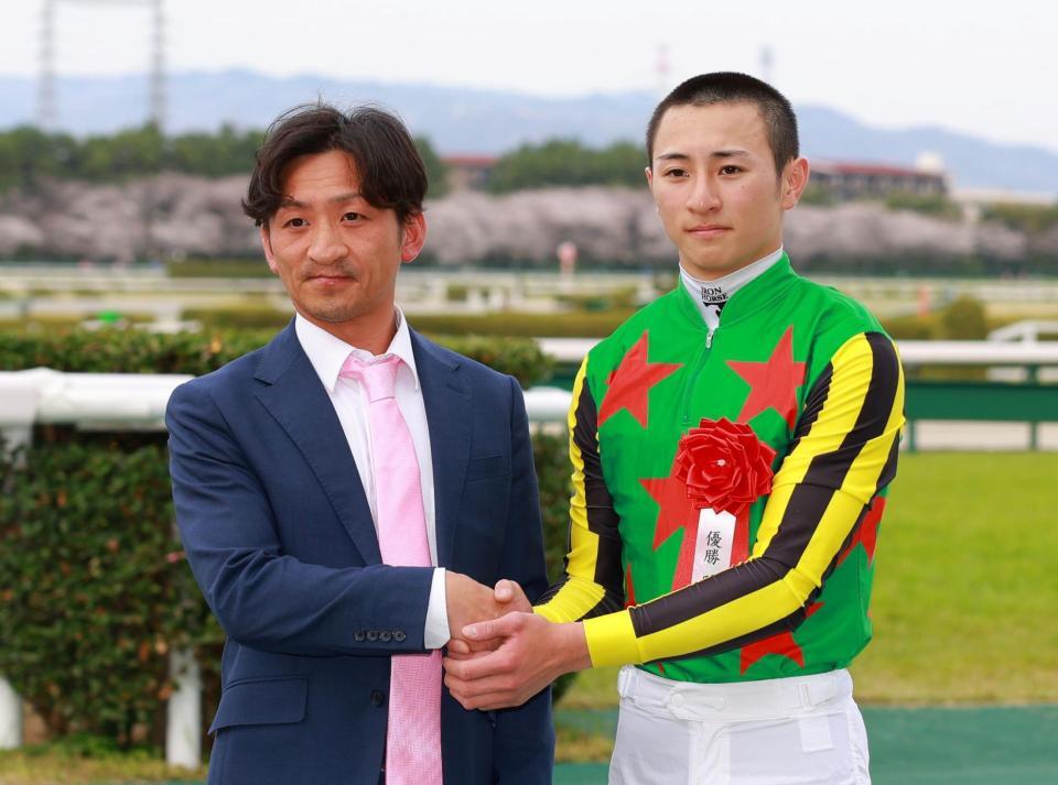 　父の吉村智洋（左）と握手を交わす吉村誠之助（撮影・石湯恒介）