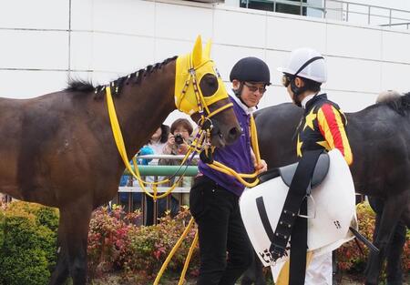 レース後、田中一征厩務員(写真中央)と目を見合わせて笑う武豊(右)