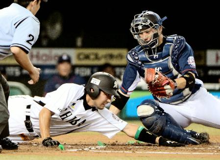 　１回ロッテ１死一、二塁、サブローの右前打で本塁を狙った二走根元がタッチアウト。捕手炭谷＝西武ドーム