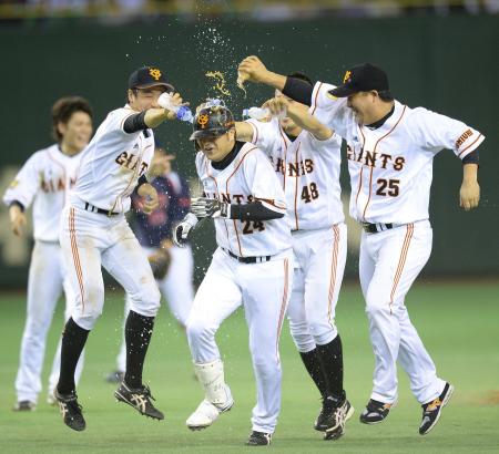 　サヨナラ打を放ち、ナインから手荒い祝福を受ける代打・高橋由（中央）＝撮影・西岡　正