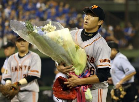 　通算１５００投球回を達成し、花束を手にする内海