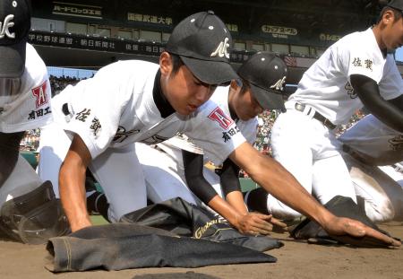 　グラウンドの土を拾い集める有田工・藤川（撮影・保田叔久）