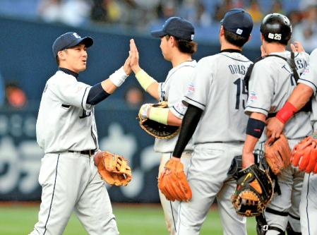 　オリックスに競り勝ちナインとハイタッチを交わす栗山（左端）（撮影・吉留常人）