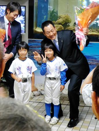 　奄美大島入りし、歓迎セレモニーで野球少女に花束を手渡される中畑監督（右）