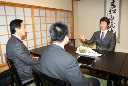 　札幌市内のホテルで、ソフトバンクの小川・編成育成部長（左）との交渉に臨む鶴岡（右）＝代表撮影