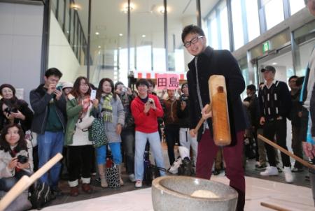 ファンに囲まれ餅をつく田島＝名古屋市熱田区