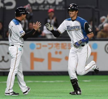 　１回、本塁打を放ち、三塁コーチに迎えられる大谷（右）＝札幌ドーム