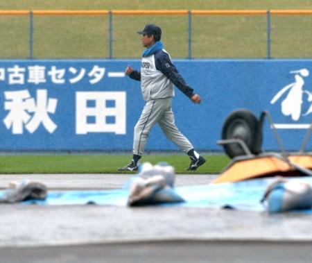 　雨のためマウンドにブルーシートがかぶせられるなか、もくもくと歩く西武・伊原監督