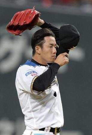 　１回、１死一、三塁のピンチに汗を拭う日本ハム・斎藤