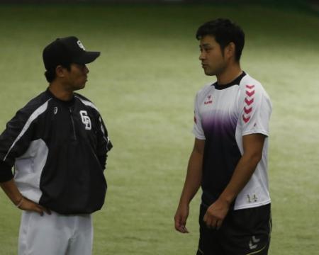 小笠原投手コーチ（左）と話す朝倉