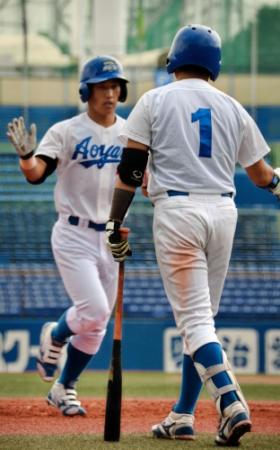 三回２死、勝ち越しのソロを放った青学大・吉田正（左）は生還してハイタッチする