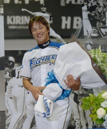 　記者会見を終え、花束を手にする日本ハムの金子誠内野手＝27日、札幌ドーム
