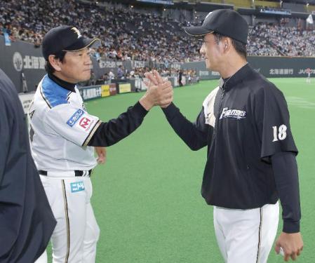 　２勝目を挙げた斎藤（右）とタッチを交わす日本ハム・栗山監督＝札幌ドーム