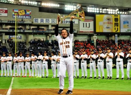 優勝トロフィーを高々と持ち上げ笑顔を見せる原監督（中央）＝撮影・園田高夫