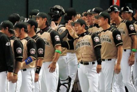 ハイタッチでナインを迎える日本ハム・栗山英樹監督＝ヤフードーム（撮影・飯室逸平）