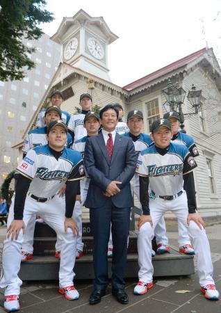 　札幌市時計台前でポーズをとる有原航平投手（前列左）ら日本ハムの新人選手。中央は栗山監督＝２１日、札幌市中央区