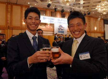 四国アイランドリーグの１０周年記念式典で乾杯する又吉（左）と山本雅＝高松市内のホテル