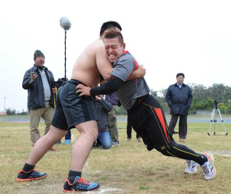 　沖縄の柔道チャンピオンと相手に押し合い、下半身を強化する大隣