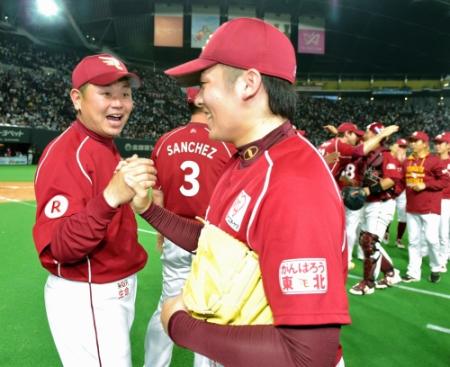　松井裕樹（手前）からウイニングボールを受け取り笑顔を見せる楽天・大久保博元監督（左）