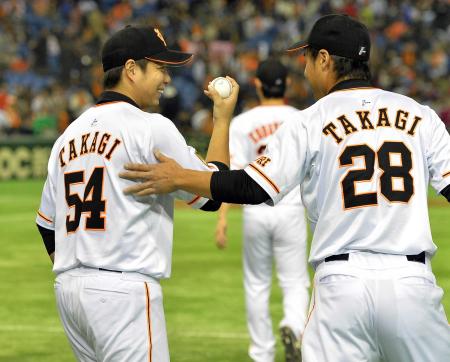 　高木勇（左）は、最後を締めた高木京からウイニングボールを受け取り笑顔を見せる