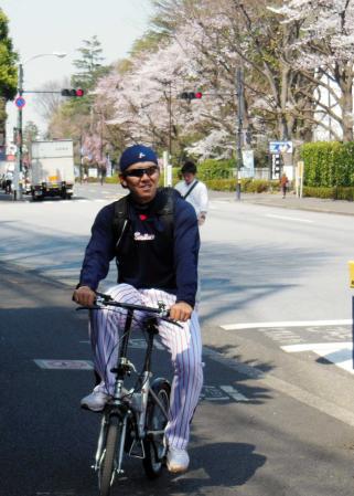 　桜が開花した神宮外苑を自転車で移動する成瀬