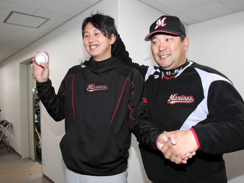 　プロ初勝利を挙げウイニングボールを手に伊東監督（右）と握手を交わす木村