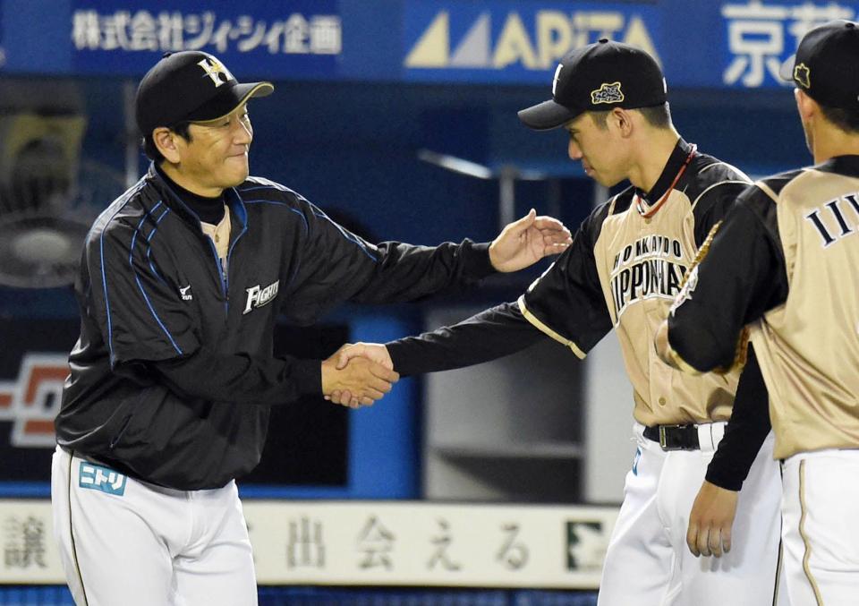 　４勝目を挙げた吉川（右）と握手する日本ハム・栗山監督＝ＱＶＣ