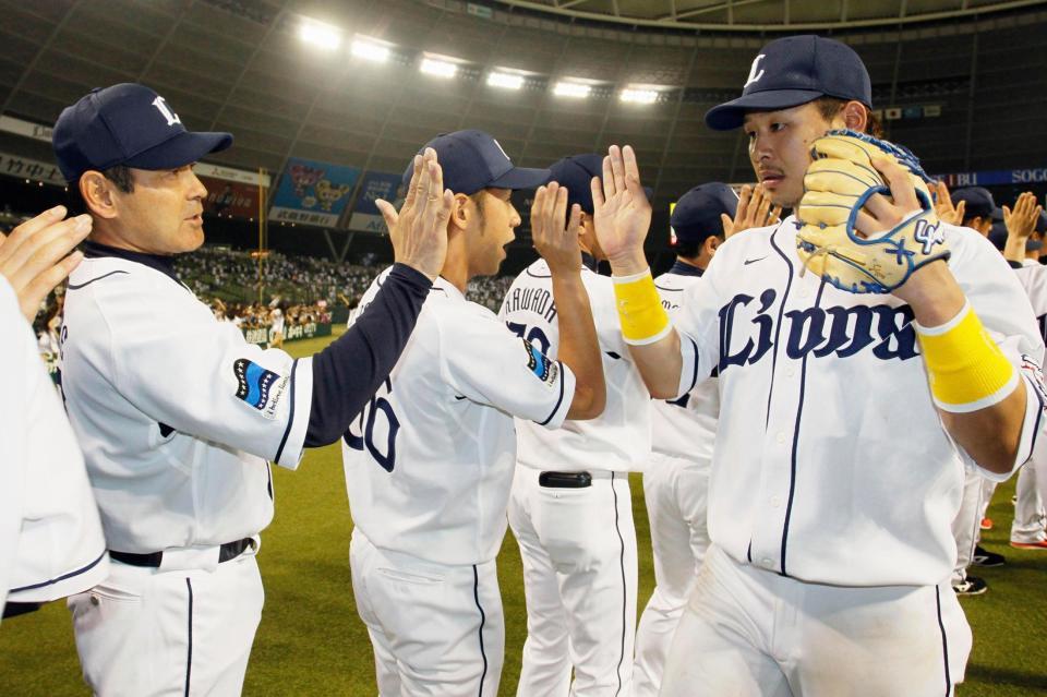 ロッテに競り勝ち、浅村（右）らナインとタッチする田辺監督（左）＝西武プリンスドーム