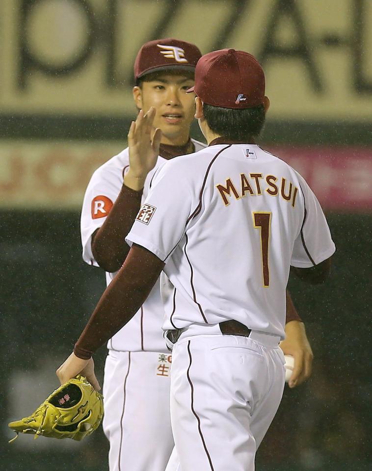 　巨人に勝利し、ハイタッチする先発の辛島（左）と松井裕