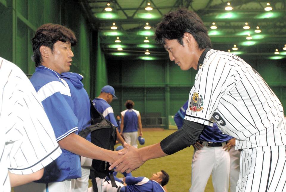 　三浦（左）にあいさつし握手する藤浪（撮影・飯室逸平）