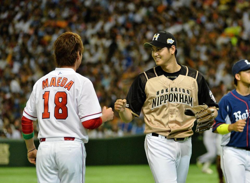 １回を三者凡退に抑え三塁コーチャーの広島・前田健太（左）と笑顔でグータッチする日本ハム・大谷＝東京ドーム（撮影・園田高夫）