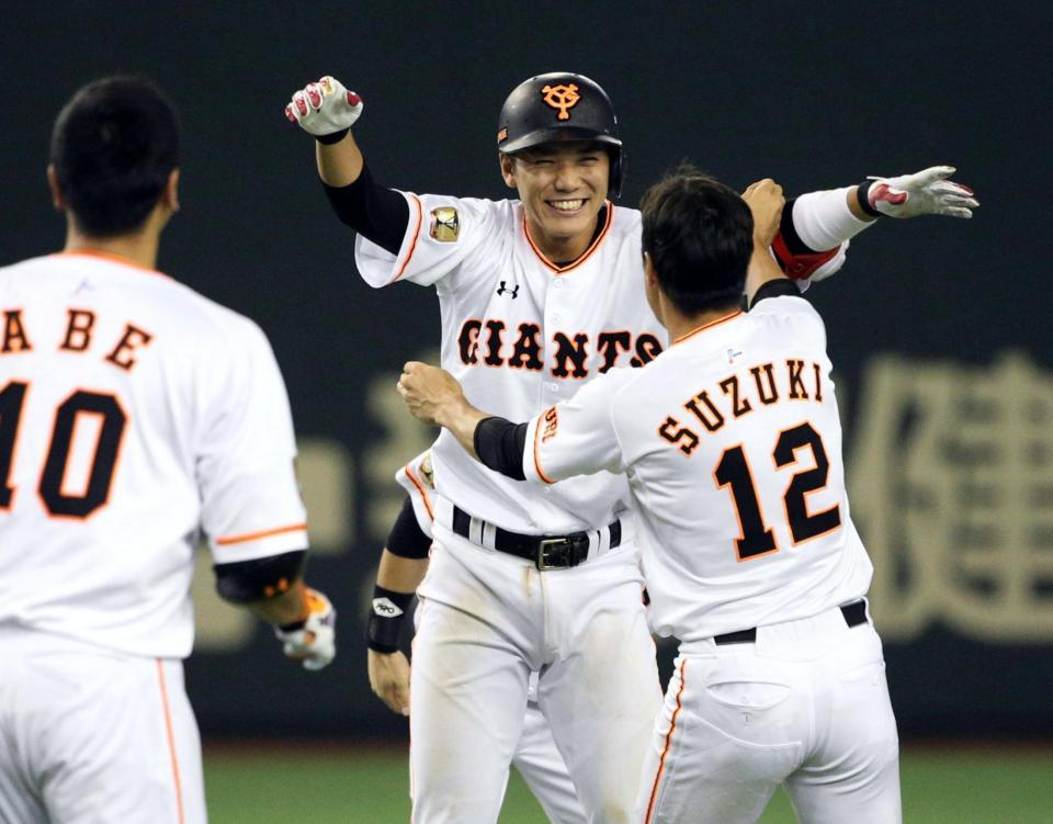 ９回、サヨナラ二塁打を放ち、鈴木（右）と抱き合って喜ぶ坂本。左は阿部＝東京ドーム