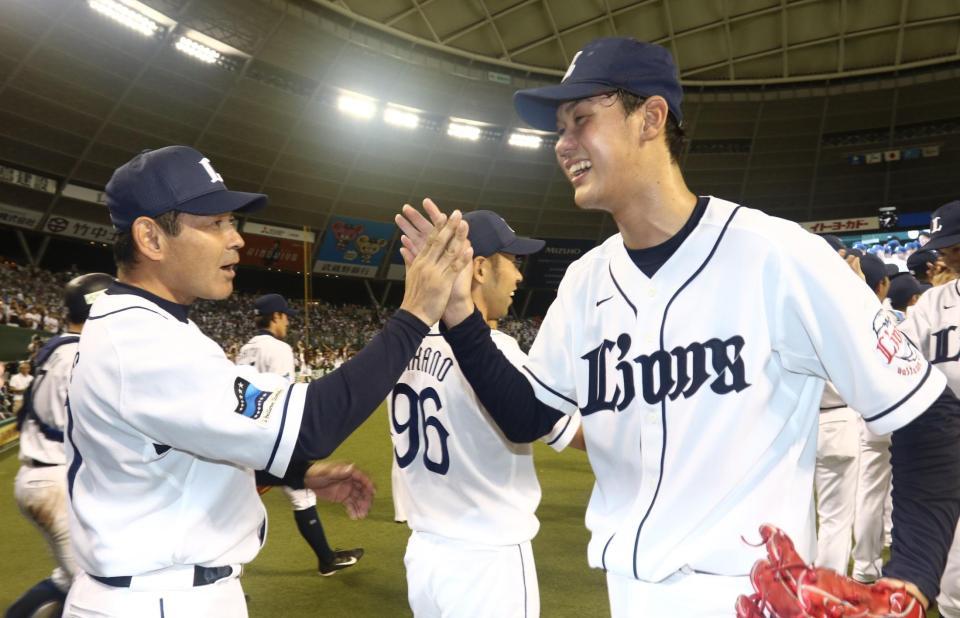 　プロ初完封勝利を挙げた高橋光（右）を迎える田辺監督