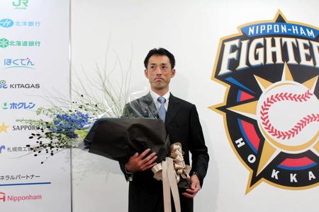 引退会見後、花束を受け取る日本ハム・木佐貫