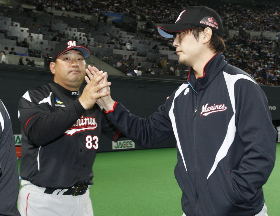 　14勝目を挙げた涌井（右）とタッチするロッテ・伊東監督＝札幌ドーム