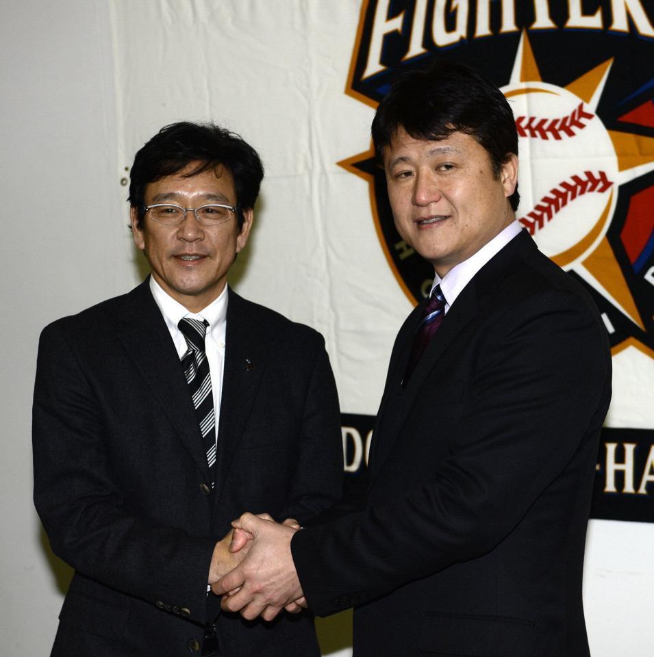 コーチ就任会見で栗山監督（左）とガッチリ握手する阿井英二郎氏（２０１３年１月１１日撮影）