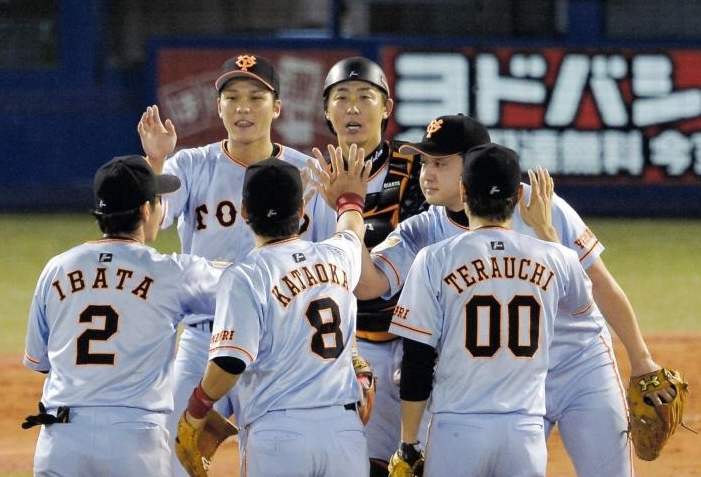 逆転勝ちでタッチをかわす坂本（左奥）と巨人ナイン＝神宮球場（撮影・堀内翔）