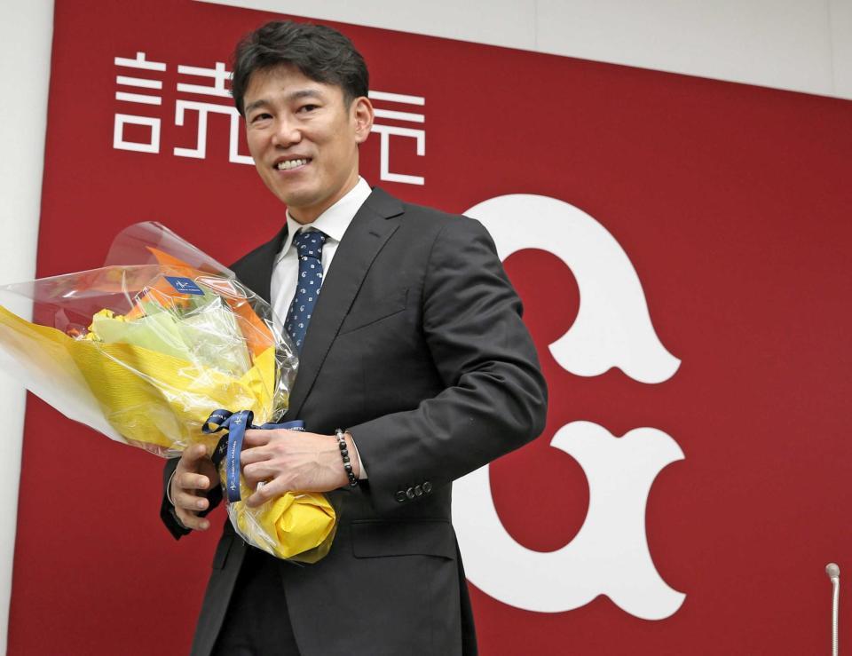 引退記者会見を終え、花束を手にする井端