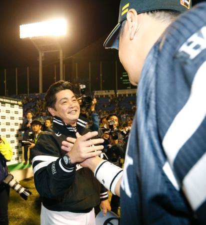 　２年連続の日本一にあと１勝とし、李大浩（手前）と握手を交わすソフトバンク・工藤監督＝神宮