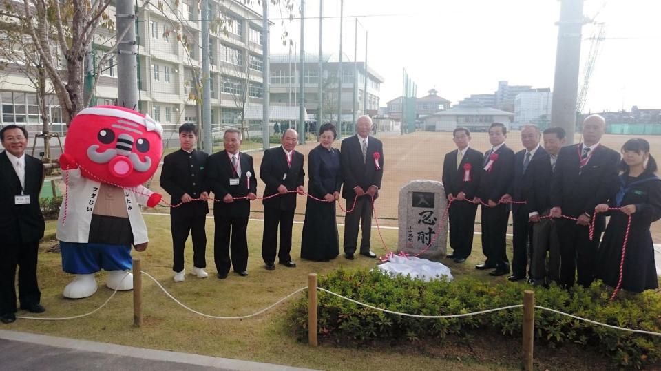 母校・二見中で記念碑の除幕式を行う小山正明氏（中央左）