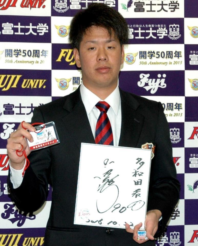 　指名のあいさつを受け、プレゼントされた田辺監督のサイン色紙とドラフトのＩＤを披露する富士大・多和田