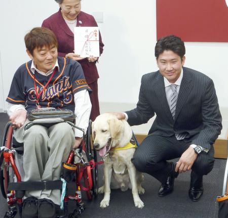 　介助犬の育成、普及のための支援金を日本介助犬協会に寄付した巨人の菅野（右）＝３日、東京・大手町の球団事務所