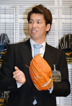 　大阪市内のイベントでグラブを手にするプロ野球広島の前田健太投手。ポスティングシステムで米大リーグ移籍を目指すことが決まった＝４日午後