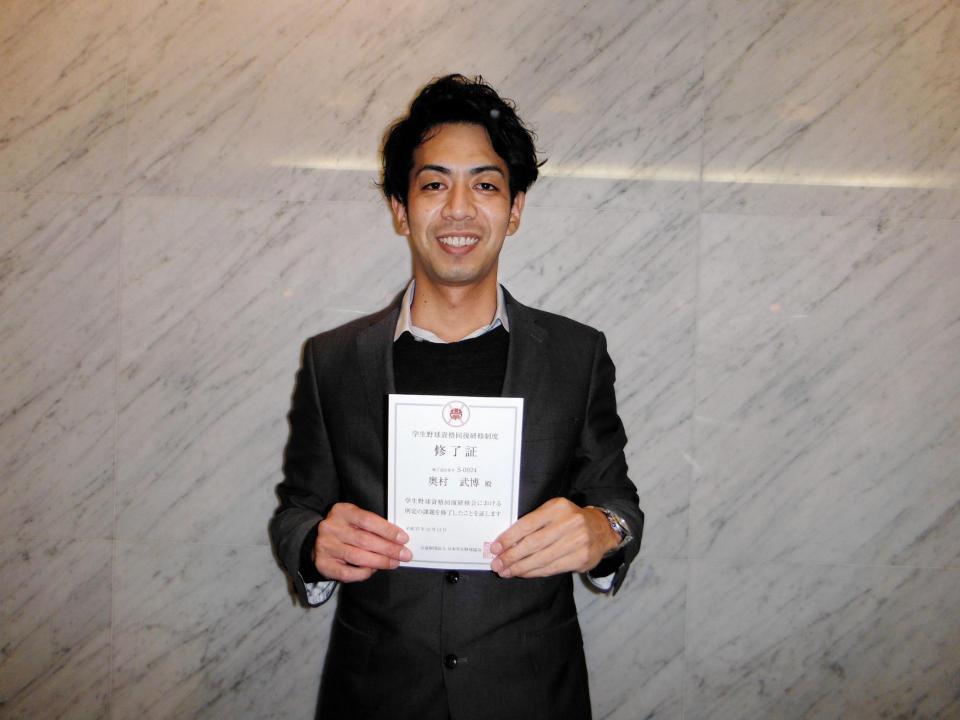 学生野球資格回復研修会の修了証を手に笑顔を見せる元阪神・奥村武博氏