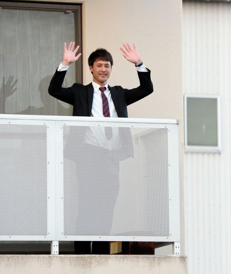 勇翔寮の自室のベランダから手を振る日本ハム１位・上原健太＝千葉・鎌ケ谷ファイターズタウン（撮影・開出牧）